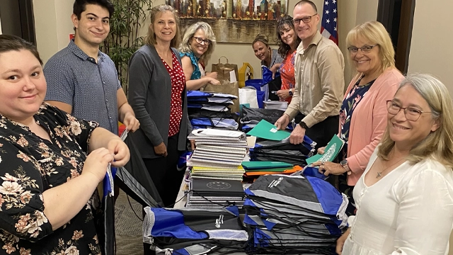 Employees volunteering to fill backpacks for students.